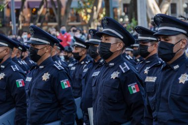 Municipal police officers stand guard in the zocalo of the city of Puebla clipart