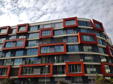 Prag, Çek Cumhuriyeti - 2 Ekim 2021: Üst düzey kırmızı pencereli modern apartman binaları bulutlu havalarda dekorasyon olarak kullanılıyor.