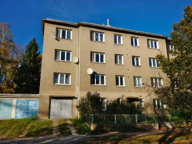 Prag, Çek Cumhuriyeti - 24 Ekim 2021: Solunda gri cephesi ve garajı olan eski tarz apartman.