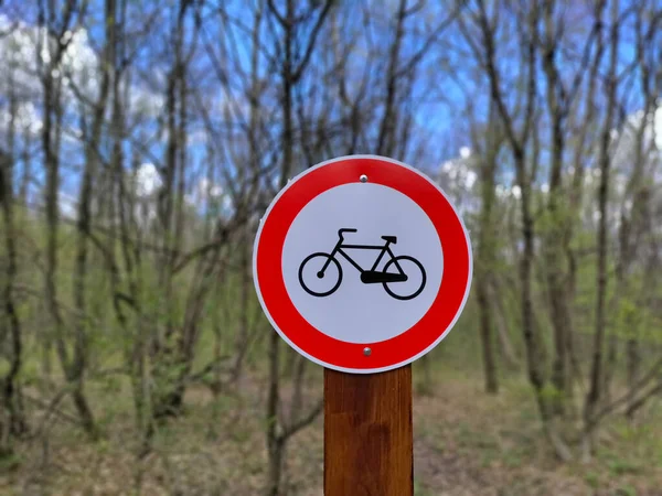 Road Sign Prohibiting Bicycles Entering Blurred Forest Background — стоковое фото