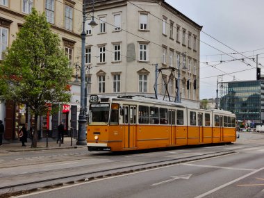 Budapeşte, Macaristan - 9 Nisan 2022: Budapeşte 'nin eski ilçesinden geçen turuncu tramvay.