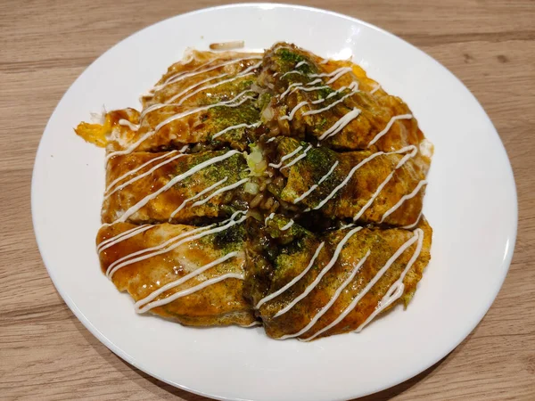 Geleneksel Hiroşima stili okonomiyaki yumurta, kızarmış erişte, marul ve mayonezden yapılır..