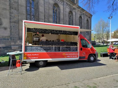 Prag, Çek Cumhuriyeti: 17 Nisan 2022 - Meksika yemeği satan bir açık hava pazarında gıda satıcısı. Kürsü tarihi kilisenin hemen yanında..