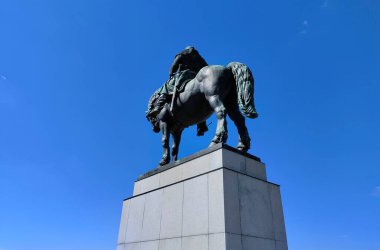 Prag, Çek Cumhuriyeti: 17 Nisan 2022 - Bronz savaşçı heykeli taştan heykeli üzerinde duruyordu. Arka plan temiz mavi gökyüzünden yapılmıştır. At arkadan görüldü..