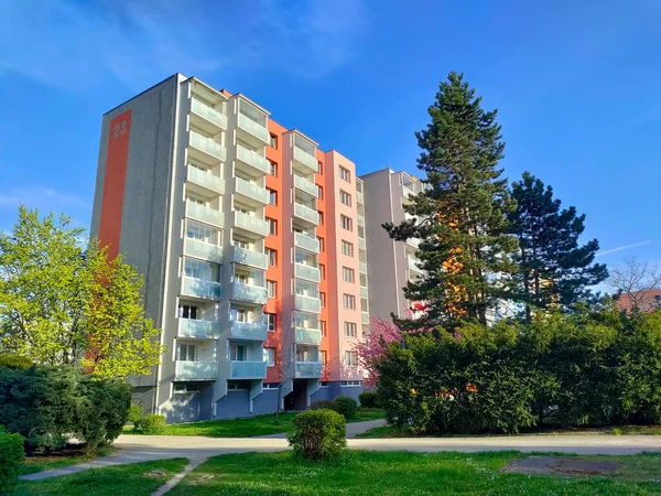 Ceske Budejovice, Çek Cumhuriyeti: 30 Nisan 2022 - Mavi ve turuncu cepheli eski tip apartman blokları. Binanın önünde bir park var. Hava güneşli..