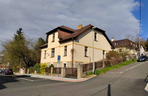 Prag, Çek Cumhuriyeti: 15 Nisan 2022 - Bulutlu bir günde iki caddenin kesiştiği noktada kırmızı çatılı ve tahta çitli tipik Çek aile evi.