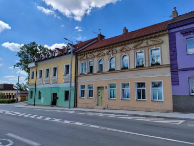 Prag, Çek Cumhuriyeti - 2 Temmuz 2022: Yolun yanında renkli cepheli iki katlı bina. Bir cephesi mor, diğeri turuncu ve sonuncusu sarı ve yeşil..