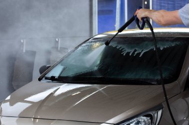 Araba yıkama, araba yıkama, ön camda köpük ve sprey boya.