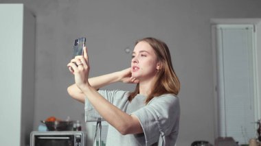 Elinde telefon olan bir kız selfie çeker.