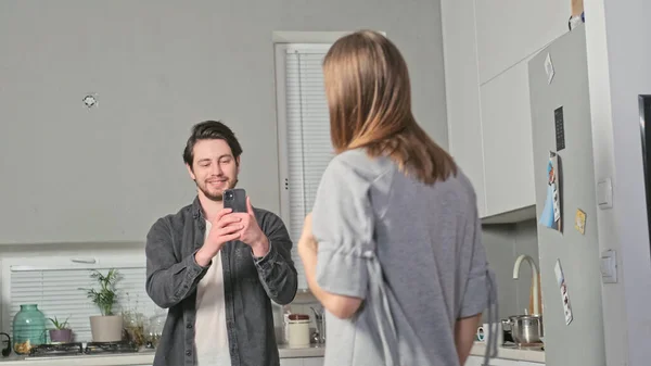 Adamın biri telefonuyla bir kızın fotoğrafını çekiyor.