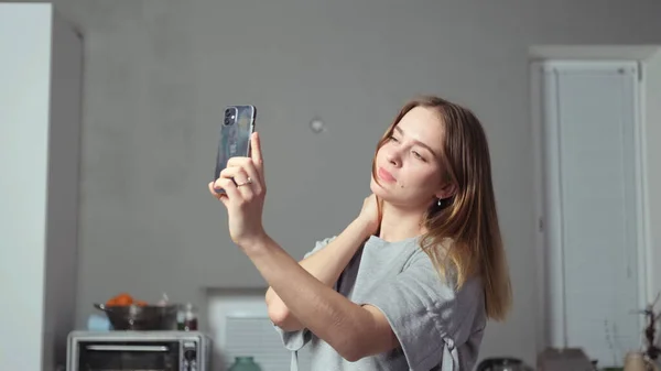 Elinde telefon olan bir kız selfie çeker.