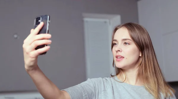 Elinde telefon olan bir kız selfie çeker.