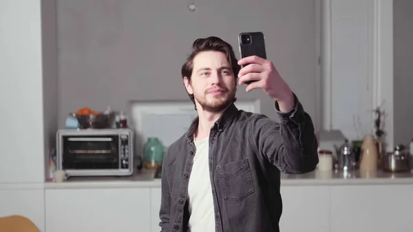 Elinde telefon olan bir adam selfie çeker.