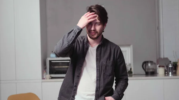 Siyah saçlı bir adam poz veriyor.