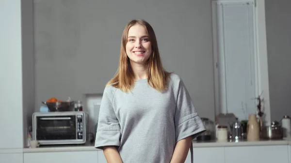 Sarı saçlı bir kız poz veriyor.