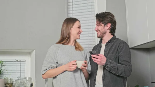 Adam ve kız mutfakta gülümsüyor.