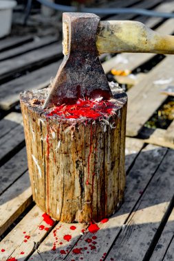 Eski ahşap bir kütükte kümes hayvanları için balta, üzerinde tüy ve kan izleri görünür. 