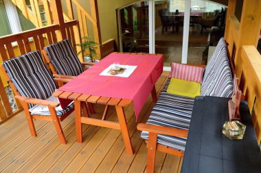 Masa ve sandalyeler balkonda.