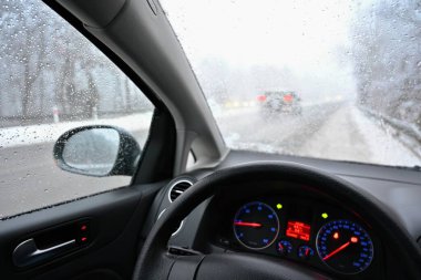 Yolda kar varken tehlikeli bir kış mevsimi. Sürücünün bakış açısından aracın içi, kötü havada tehlikeli trafik..