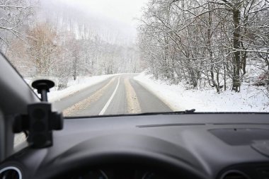 Yolda kar varken tehlikeli bir kış mevsimi. Sürücünün bakış açısından aracın içi, kötü havada tehlikeli trafik..
