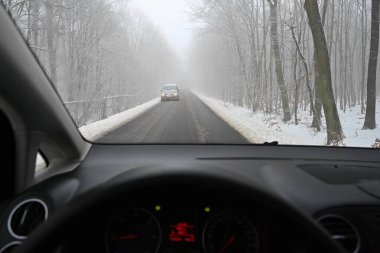 Yolda kar varken tehlikeli bir kış mevsimi. Sürücünün bakış açısından aracın içi, kötü havada tehlikeli trafik..