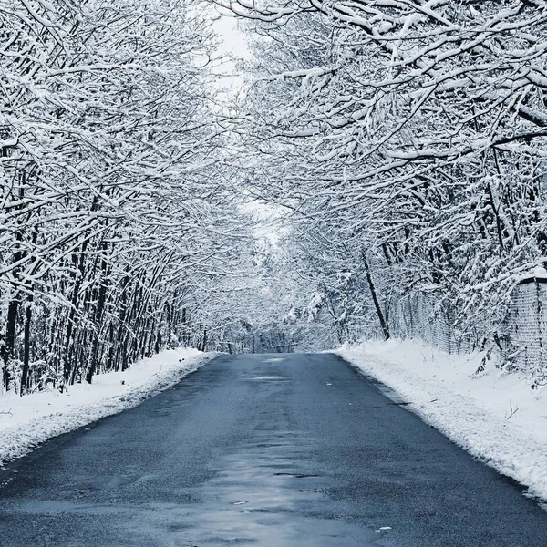 겨울에는 고드름으로 아스팔트 도로가 부서지고 수리되었다 겨울철 날씨가 여행에 — 스톡 사진