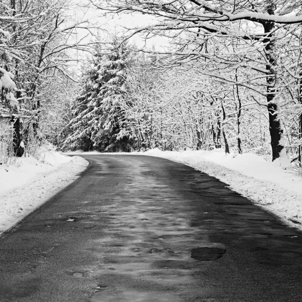 겨울에는 고드름으로 아스팔트 도로가 부서지고 수리되었다 겨울철 날씨가 여행에 — 스톡 사진