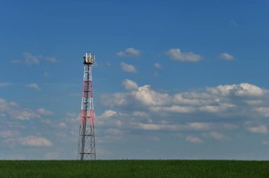 Sahadaki cep telefonlarının gsm sinyalleri için verici. Arka planda bulutlu mavi gökyüzü. Modern teknoloji ve endüstri kavramı - Telekomünikasyon Kulesi.