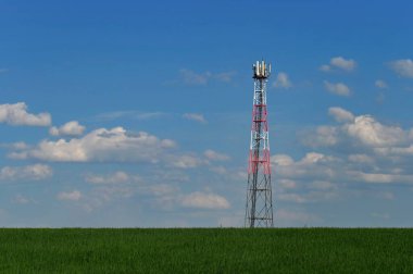 Sahadaki cep telefonlarının gsm sinyalleri için verici. Arka planda bulutlu mavi gökyüzü. Modern teknoloji ve endüstri kavramı - Telekomünikasyon Kulesi.