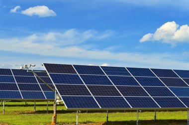 Güneş enerjisi santrali - elektrik ve ekoloji endüstrisi konsepti. Yüksek enerji fiyatları. Güzel bir manzara ve mavi gökyüzü ile güneşli bir gün. Fotovoltaik enerji santrali.