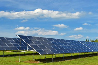 Güneş enerjisi santrali - elektrik ve ekoloji endüstrisi konsepti. Yüksek enerji fiyatları. Güzel bir manzara ve mavi gökyüzü ile güneşli bir gün. Fotovoltaik enerji santrali.