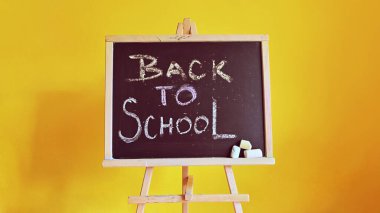Blackboard - back to school. Concept for education and school on yellow background.