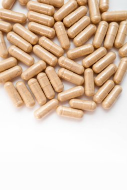 Beyaz arka planda kahverengi kapsül hapları