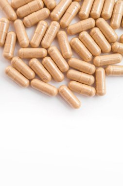 Beyaz arka planda kahverengi kapsül hapları