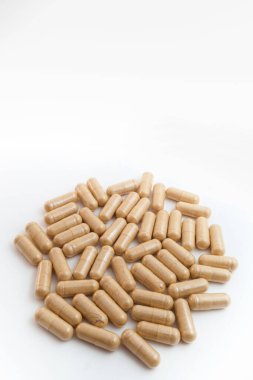 Beyaz arka planda kahverengi kapsül hapları
