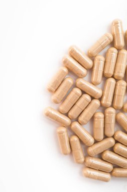 Beyaz arka planda kahverengi kapsül hapları