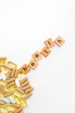 Farklı hapların beyaz arka planında tahta küplerle yazıtlar.