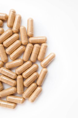 Beyaz arka planda kahverengi kapsül hapları