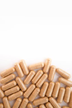 Beyaz arka planda kahverengi kapsül hapları