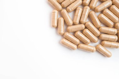 Beyaz arka planda kahverengi kapsül hapları