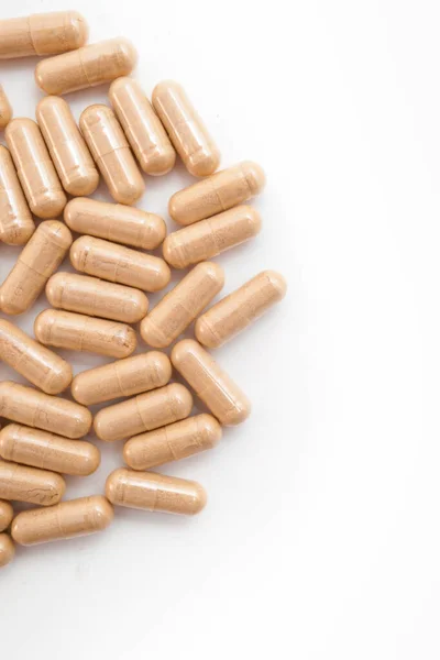 Beyaz arka planda kahverengi kapsül hapları