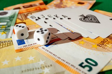 Chisinau, Moldova - 20. On iki. 2020 zar, kumarhane dolarları ve euro banknotlarıyla yeşil kumaş üzerinde kağıt oynamak. 