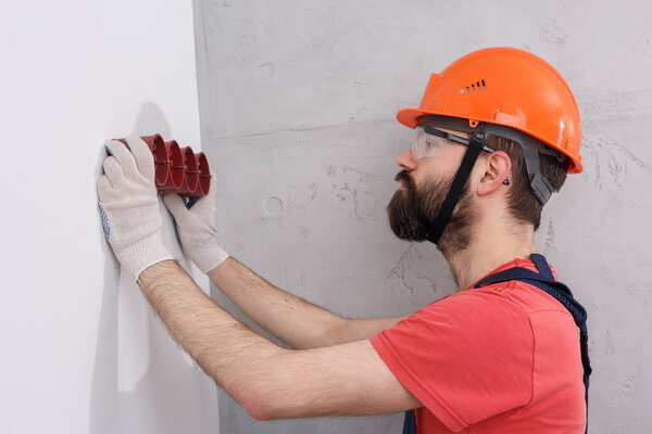 electrician in helmet installs sockets