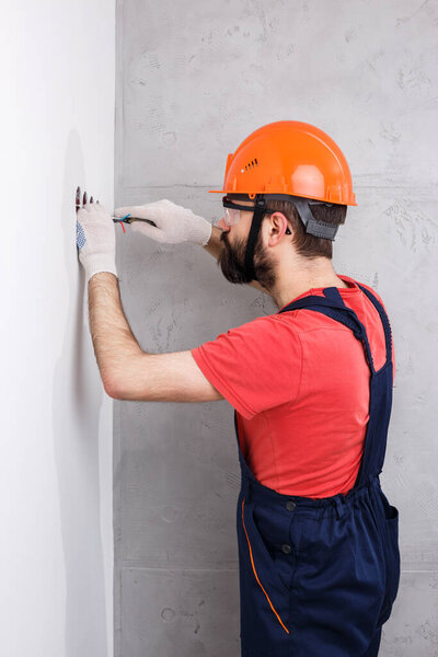 electrician in helmet installs sockets