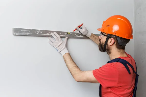 Een Werknemer Met Een Oranje Helm Controleert Muren Met Een — Stockfoto