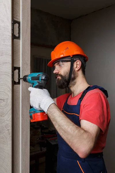 Travailleur Avec Une Perceuse Dans Casque Orange Installe Une Porte — Photo