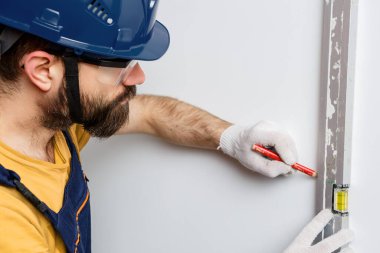 Turuncu kasklı bir işçi su seviyesiyle duvarları kontrol edecek.