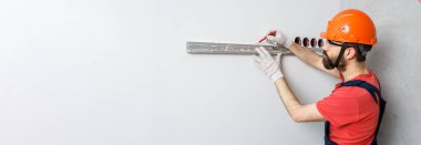 Turuncu kasklı bir işçi su seviyesiyle duvarları kontrol edecek.