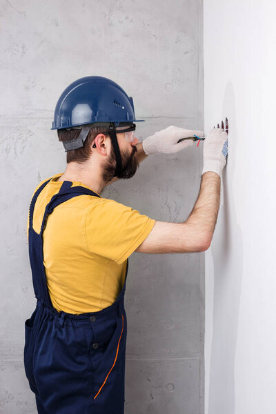 electrician in helmet installs sockets