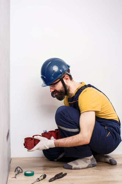 electrician in helmet installs sockets